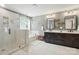 Modern bathroom featuring a glass shower, soaking tub, double vanity with dark cabinets and tile floors at 110 St Sophia Ct, Mooresville, NC 28117