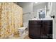 Bathroom featuring a floral shower curtain, toilet, and dark-stained vanity with white countertop at 110 St Sophia Ct, Mooresville, NC 28117