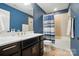 Bathroom showcasing a white vanity, tile flooring, and shower-tub combo with blue shower curtain at 110 St Sophia Ct, Mooresville, NC 28117
