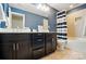 Bathroom featuring dual vanity sinks, dark cabinets, and tub with tile surround at 110 St Sophia Ct, Mooresville, NC 28117