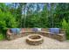 Outdoor fire pit surrounded by a built-in stone bench with cushions at 110 St Sophia Ct, Mooresville, NC 28117