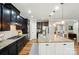 Open concept kitchen featuring dark cabinetry, granite countertops, stainless appliances, and island with seating at 110 St Sophia Ct, Mooresville, NC 28117