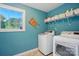 Laundry room with blue walls and modern washer and dryer units at 110 St Sophia Ct, Mooresville, NC 28117