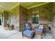 Charming covered porch with brick, inviting seating area with wicker chairs and blue cushions at 110 St Sophia Ct, Mooresville, NC 28117