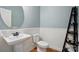 Stylish powder room with pedestal sink, decorative mirror, beadboard detail, and wood-look flooring at 110 St Sophia Ct, Mooresville, NC 28117