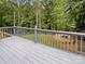 Wood deck with gray railings overlooks a private backyard and lush green trees at 12092 Spinnaker Dr, Fort Mill, SC 29708