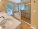 Well-lit bathroom with a double vanity, soaking tub, and glass-enclosed shower at 12092 Spinnaker Dr, Fort Mill, SC 29708