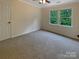 Neutral bedroom featuring a window with view of the lush surrounding trees at 12092 Spinnaker Dr, Fort Mill, SC 29708