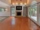 Spacious living room with hardwood floors, a stone fireplace, and large windows at 12092 Spinnaker Dr, Fort Mill, SC 29708