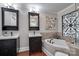 Bathroom showcasing dual vanities, tile floors, and a standalone tub at 12311 Bentcreek Ln, Matthews, NC 28105