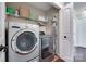 Functional laundry room featuring a modern washer, dryer, and shelving for storage at 12311 Bentcreek Ln, Matthews, NC 28105