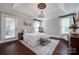 Primary bedroom featuring tray ceiling, hardwood floors, natural light, and stylish furnishings at 12311 Bentcreek Ln, Matthews, NC 28105