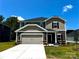 Two-story home featuring a gray-beige exterior, two-car garage, and manicured front yard at 1423 Windy Park Dr, Stanley, NC 28164