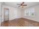 Bright bedroom featuring hardwood floors, a ceiling fan, and natural light from the shuttered window at 150 Haddonsfield Dr, Mooresville, NC 28115