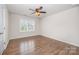 Bright bedroom featuring hardwood floors, a ceiling fan, and a large window at 150 Haddonsfield Dr, Mooresville, NC 28115