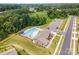 Aerial view of community pool and amenity center with lounge chairs and parking under a summer sky at 150 Haddonsfield Dr, Mooresville, NC 28115