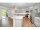 Bright kitchen features stainless steel appliances, a large island and elegant chandelier lighting at 150 Haddonsfield Dr, Mooresville, NC 28115