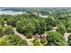 Aerial view of a beautiful home nestled among lush greenery with a serene lake in the background at 150 Pinnacle Shores Dr, Mooresville, NC 28117