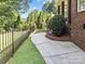Landscaped backyard featuring green grass, an iron fence, and mature trees at 150 Pinnacle Shores Dr, Mooresville, NC 28117