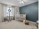 Cozy Bedroom room with a white crib, decorative lamp, and a plush rug, with a pale blue accent wall at 150 Pinnacle Shores Dr, Mooresville, NC 28117
