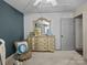 Charming bedroom featuring a light yellow dresser with vintage mirror and plush chair at 150 Pinnacle Shores Dr, Mooresville, NC 28117