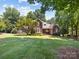 Inviting brick two-story home with well-maintained landscaping and mature trees on a bright day at 150 Pinnacle Shores Dr, Mooresville, NC 28117