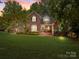 Charming brick two-story home with lush landscaping and a sprawling front lawn at sunset at 150 Pinnacle Shores Dr, Mooresville, NC 28117