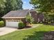 Side view of a brick home with an attached two-car garage and well-kept lawn at 150 Pinnacle Shores Dr, Mooresville, NC 28117