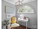 Charming office area with a large arched window, a vintage chair, desk and decor at 150 Pinnacle Shores Dr, Mooresville, NC 28117