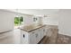 Kitchen island with granite countertop, white cabinets, and vinyl flooring, adjacent to a dining area at 1709 White Willow Ave, Gastonia, NC 28054
