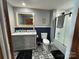 Updated bathroom featuring decorative tile floor, modern vanity, and tub-shower with glass enclosure at 200 Prospect Church Rd, Albemarle, NC 28001