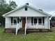 Charming home with a covered front porch, white siding, and black shutters at 200 Prospect Church Rd, Albemarle, NC 28001