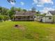 Spacious green backyard with tree stump, house with lattice patio, and small white house with white fence at 216 Hillcrest Pl, Salisbury, NC 28144
