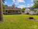 Spacious backyard with lawn, patio, tree stump, and a white house surrounded by a white picket fence at 216 Hillcrest Pl, Salisbury, NC 28144