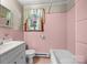 Bathroom with pink tiling featuring a vanity, toilet, and bathtub at 216 Hillcrest Pl, Salisbury, NC 28144