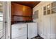 Laundry area featuring both a washer and dryer along with wooden cabinets for storage at 216 Hillcrest Pl, Salisbury, NC 28144