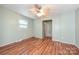 Bedroom with hardwood floors, a ceiling fan, a large window, and an entrance to another room at 267 Buffalo Nw Ave, Concord, NC 28025