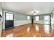 Bright living room with hardwood floors, a ceiling fan, and natural light from the front door and two windows at 267 Buffalo Nw Ave, Concord, NC 28025