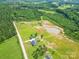 Expansive aerial view of a property featuring a home, a pond, lush green fields, and surrounding woodlands at 2737 Bobcat Rd, Heath Springs, SC 29058