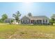 Sprawling property with a well-manicured lawn, detached garage, and a charming single-story home with a inviting front porch at 2737 Bobcat Rd, Heath Springs, SC 29058
