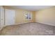Neutral bedroom featuring tan walls, carpet, and a bright window at 2809 Markland Dr, Charlotte, NC 28208