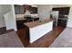 Well-equipped kitchen featuring dark cabinets, stainless steel appliances, and a kitchen island at 3014 Green Apple Dr, Dallas, NC 28034