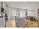 Open kitchen with a quartz island, bar stools, and a dining area in a bright, modern space at 3108 Beeler Ln, Charlotte, NC 28208