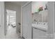 Convenient laundry area with modern washer and dryer units and shelving at 3108 Beeler Ln, Charlotte, NC 28208