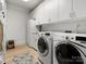 Clean, bright laundry room featuring white cabinets and modern washer and dryer units at 315 Mountainview Dr, Charlotte, NC 28270