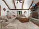 Cozy living room featuring exposed beams, a stone fireplace, comfortable seating, and hardwood floors at 315 Mountainview Dr, Charlotte, NC 28270