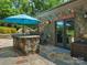Outdoor kitchen with stone countertop, grill, umbrella, and views of the pool area at 315 Mountainview Dr, Charlotte, NC 28270