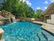 Stunning pool features a waterfall, slide, and stone accents, perfect for outdoor entertaining at 315 Mountainview Dr, Charlotte, NC 28270