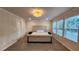 Large primary bedroom with tufted headboard, neutral colors, and multiple windows at 332 Cranford Dr, Pineville, NC 28134