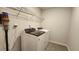 Modern laundry room with front-loading washer and dryer and wire shelving at 332 Cranford Dr, Pineville, NC 28134